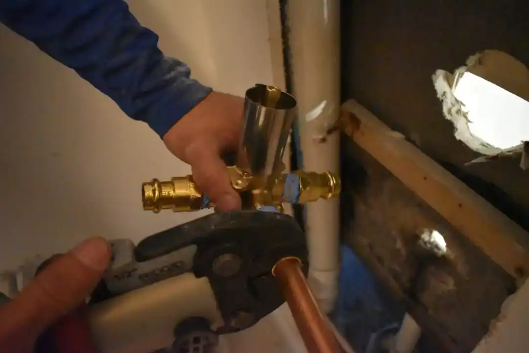 Plumber working on exposed piping during an installation