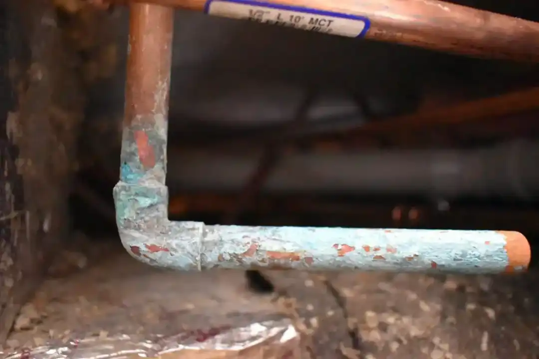 Close-up of rusted copper pipes before replacement.