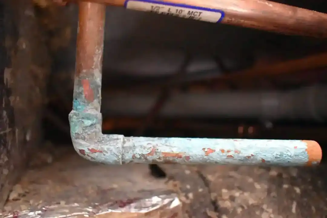 Corroded copper water line with heavy oxidation before replacement