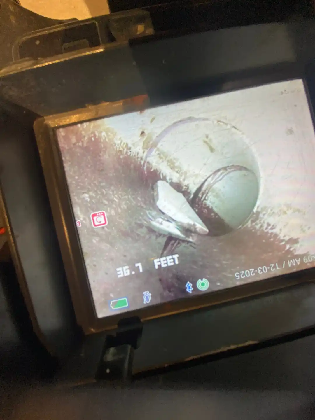 Technician using a drain camera reel for residential line inspection