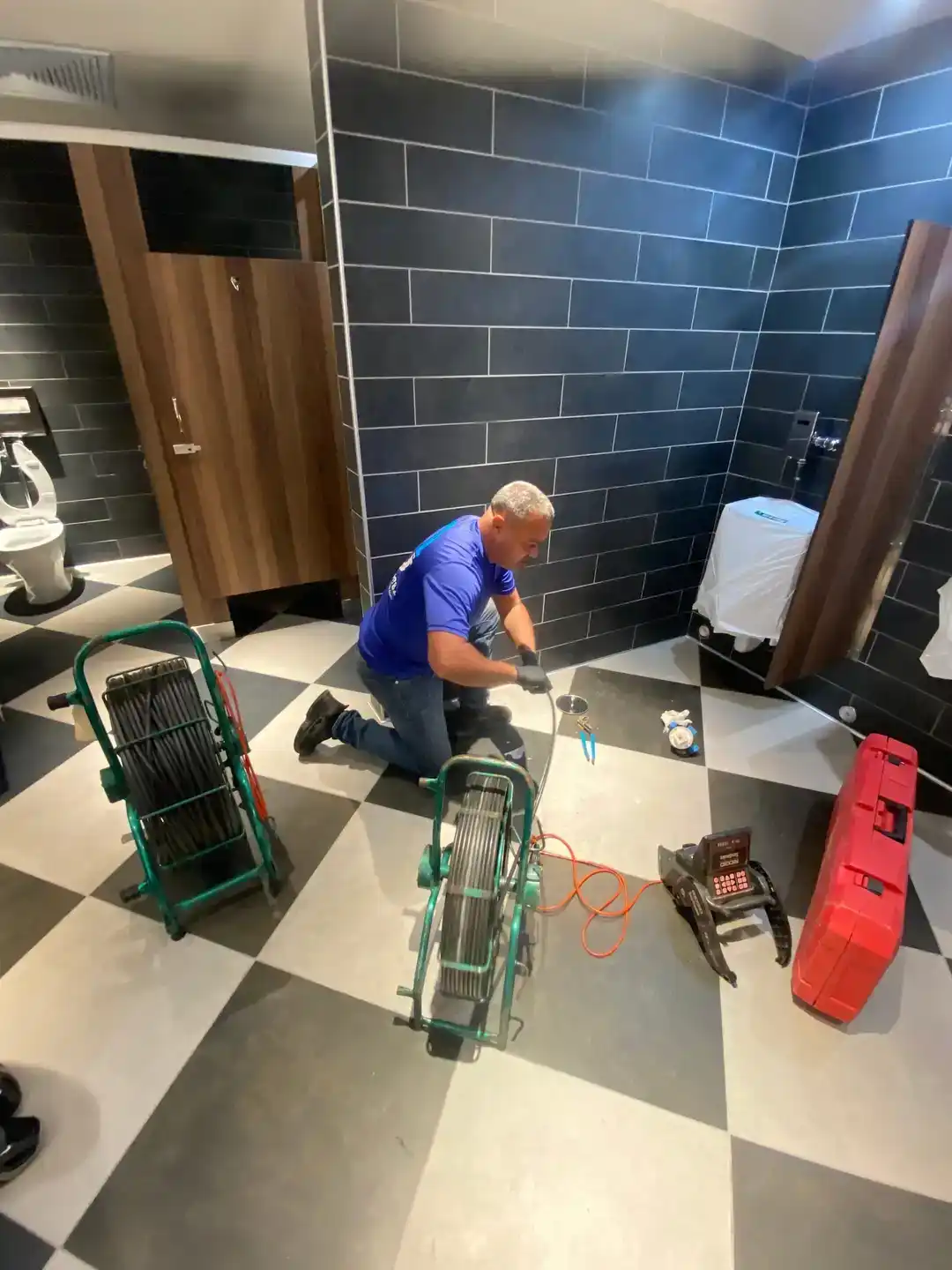 Technician inspecting a bathroom drain line with sewer-camera equipment