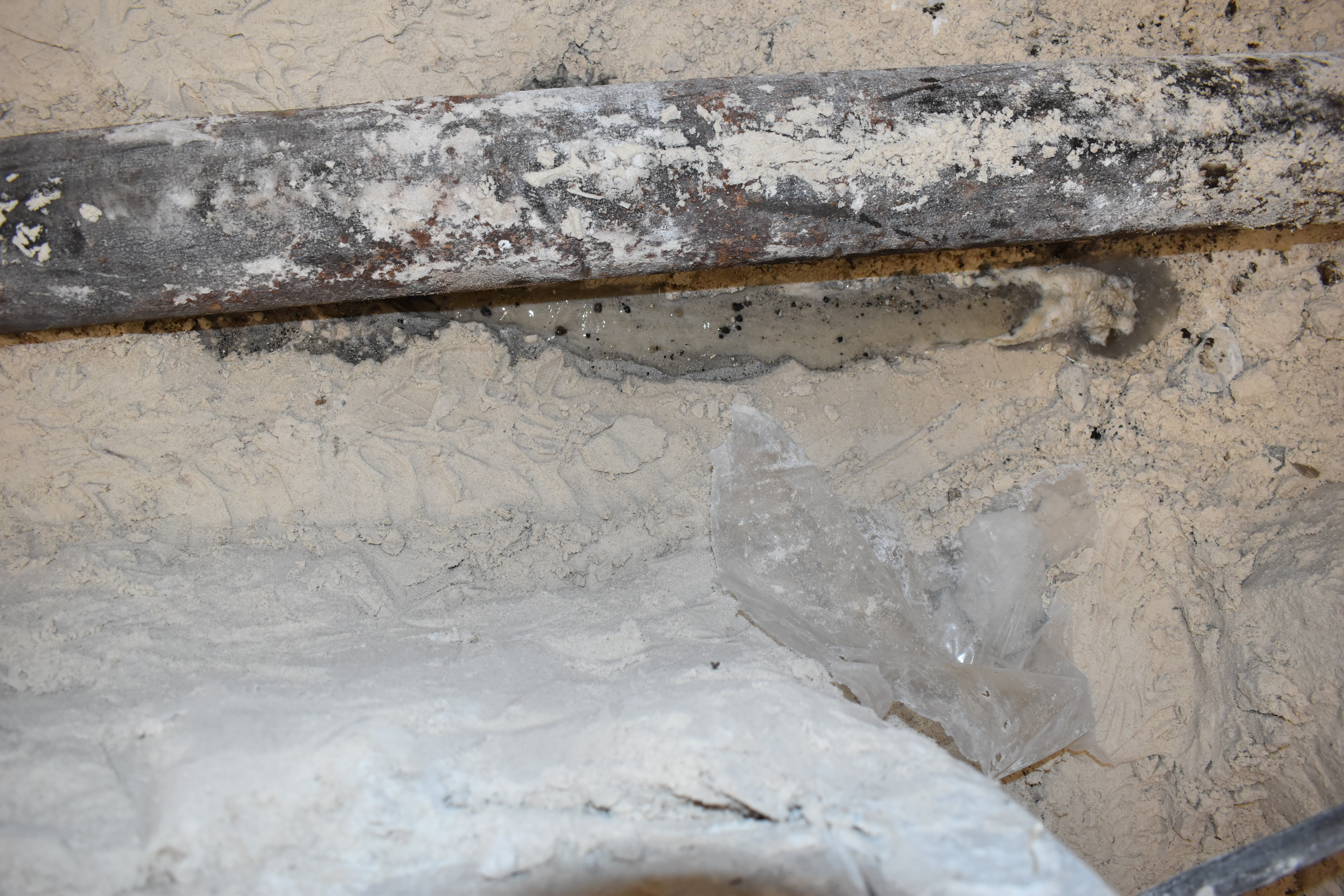 Close-up of corroded cast iron pipe showing severe deterioration