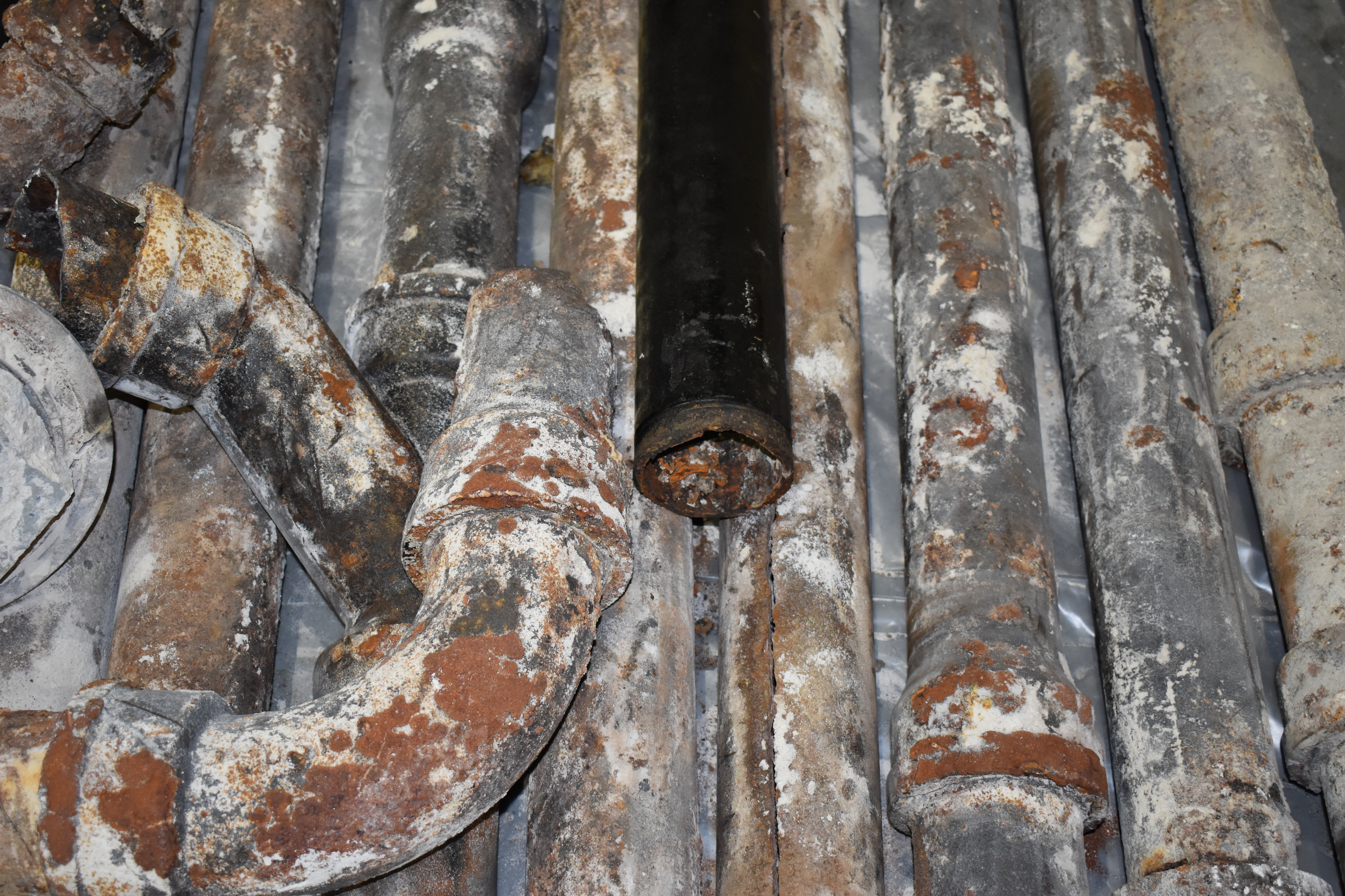 Old damaged cast iron pipes after removal showing extent of deterioration
